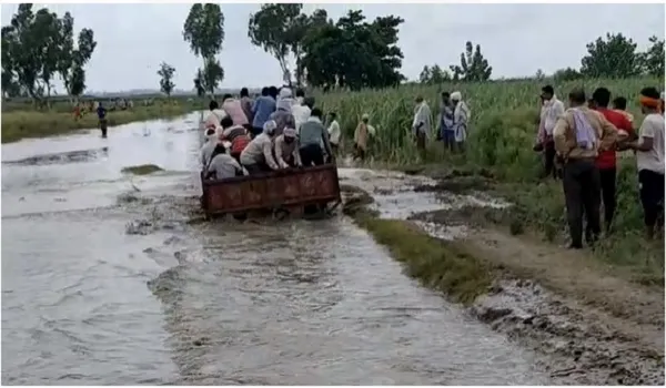 अमरोहा: गंगा का जलस्तर बढ़ने से अंतिम संस्कार में दिक्कत, गहरे पानी से गुजर रहा ट्रैक्टर