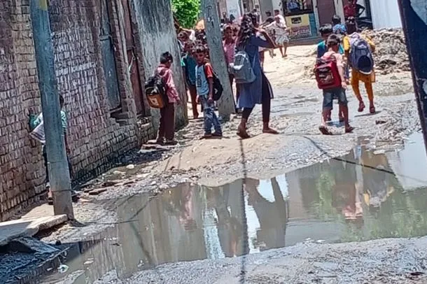 बरेली: कीचड़ से होकर गुजर रहे स्कूली बच्चे, परमिशन मिलने के बाद भी नहीं पड़ा रोड