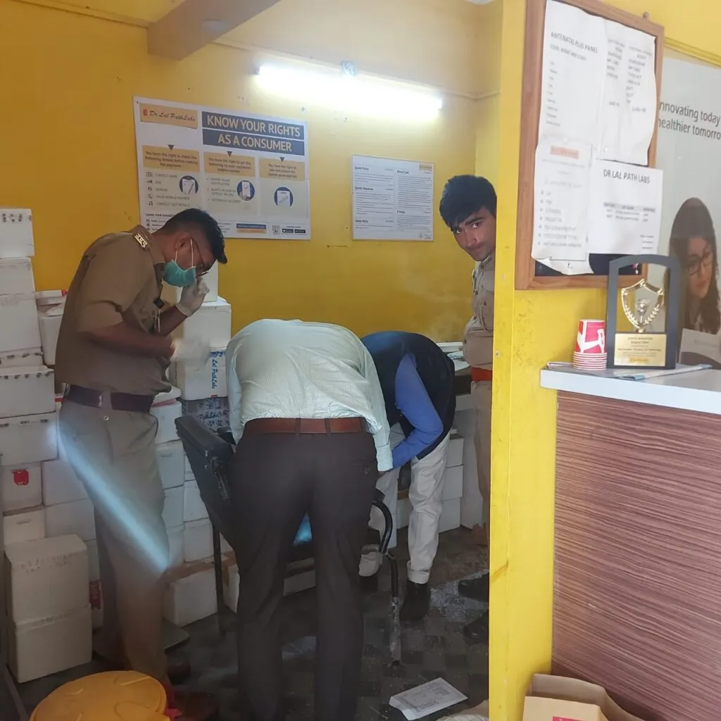 पैथोलॉजी लैब में जांच करती पुलिस टीम।
