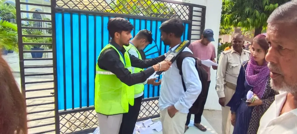 परीक्षा केंद्र पर एंट्री के दौरान चेकिंग करता स्टाफ।