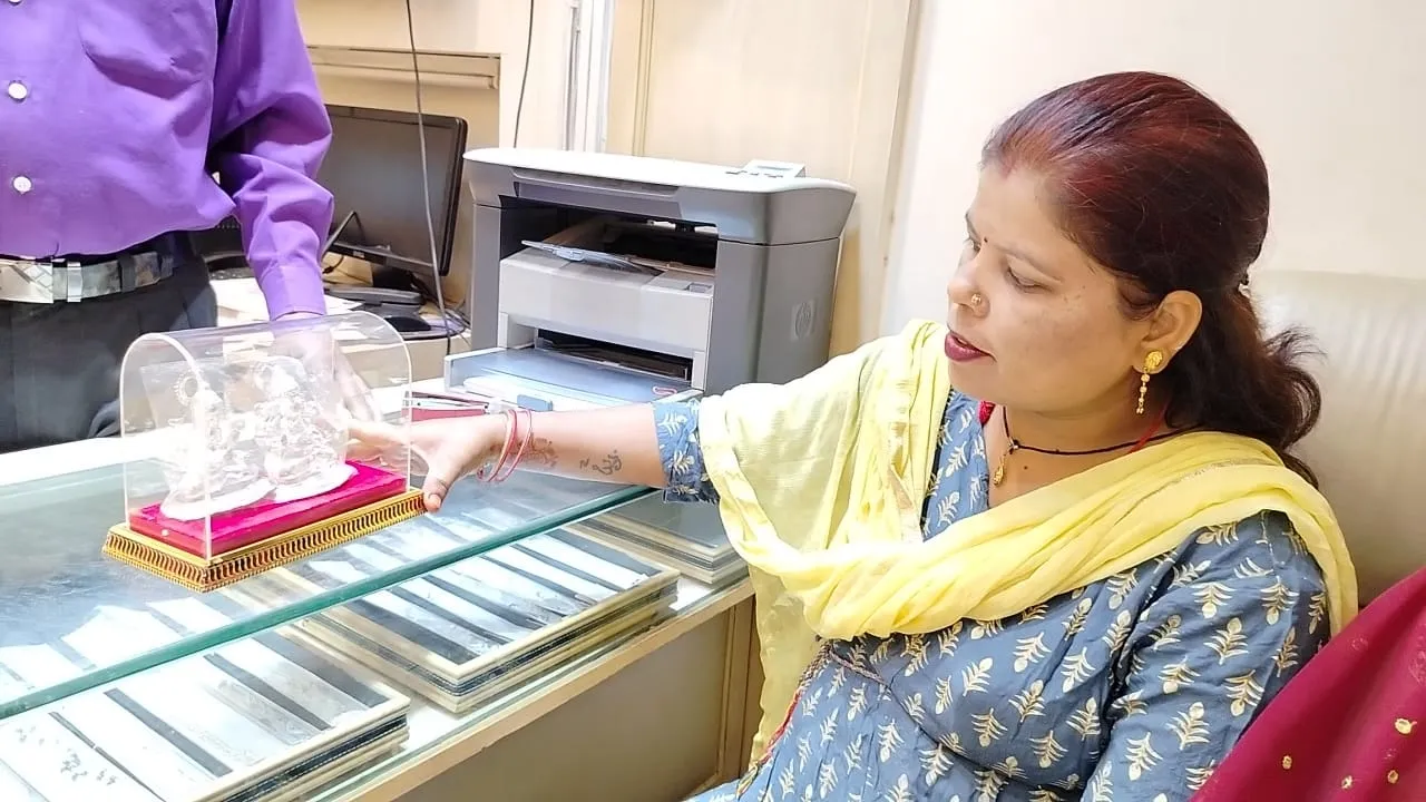 सर्राफा की दुकान में दिवाली की पूजा को गणेश जी की मूर्ति खरीद की महिला