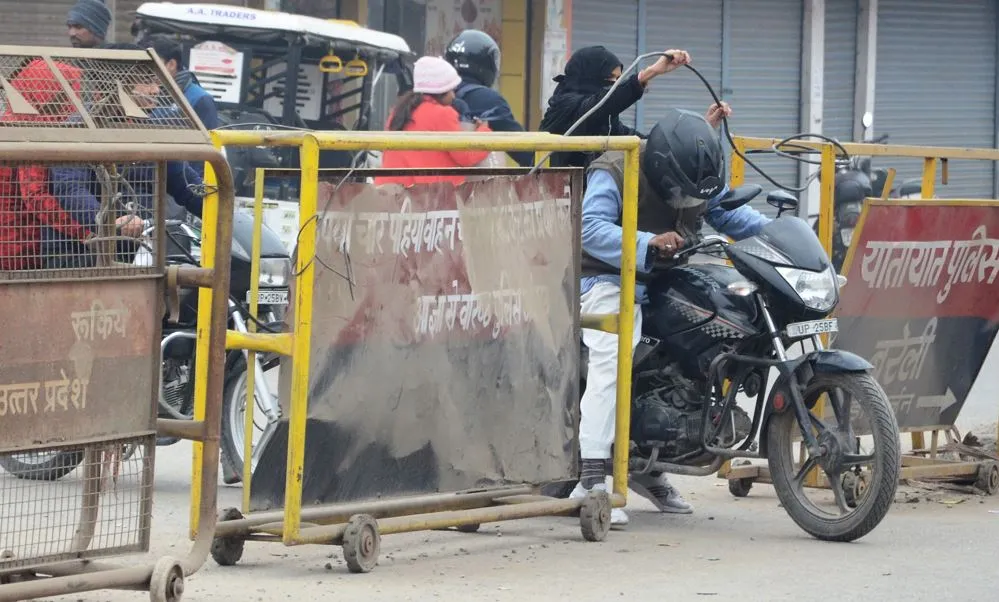 बरेली: जाम से निजात दिलाने को बनी बैरिकेडिंग के नीचे से निकल रहे लोग
