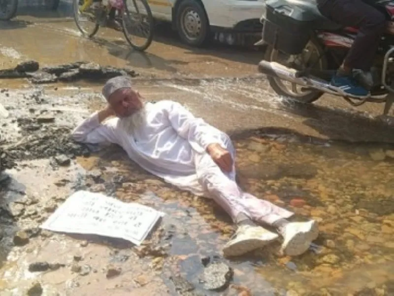 वाराणसी : सड़क पर बर्बाद हो रहा पानी, पूर्व पार्षद ने लेट कर जताया विरोध 