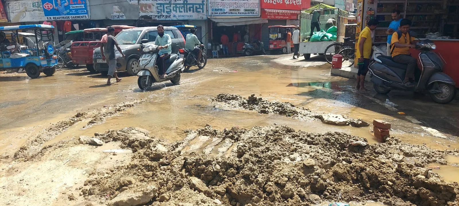 शाहजहांपुर: सीवर के गड्ढे में ट्रक फंसने से पाइप लाइन टूटी, दुकानों में भरा पानी