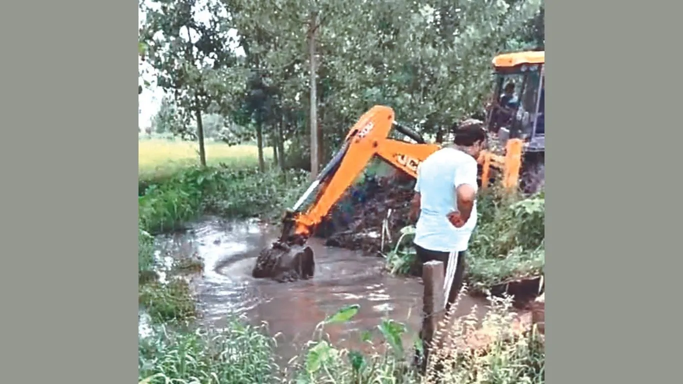 Dineshpur: झमाझम हुई बारिश से बंद नहर व बरसाती नाला को जेसीबी से खुलवाया