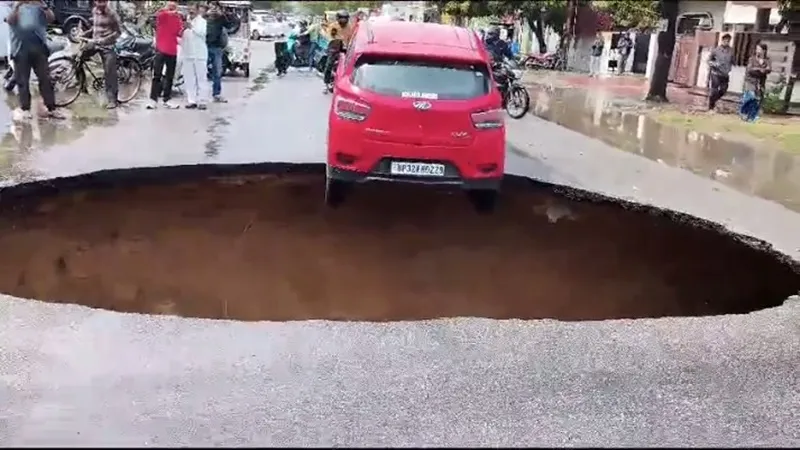 लखनऊ में बारिश के चलते विकास नगर में धंसी सड़क, लटकी कार, देखें वीडियो