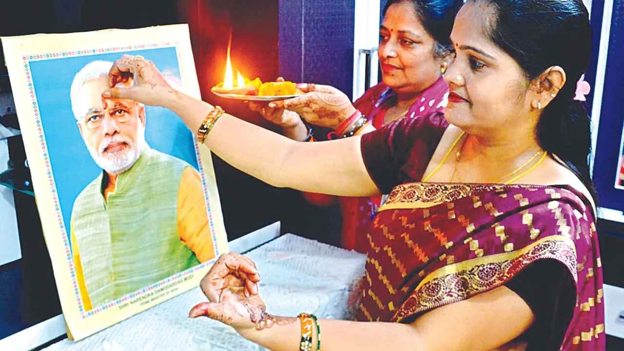 मोदी की फोटो पर तिलक करतीं महिलाएं