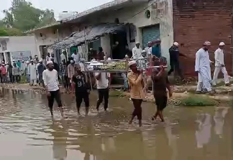 Sambhal News : महिला का जनाजा लेकर जलभराव से गुजरे लोग, वीडियो वायरल
