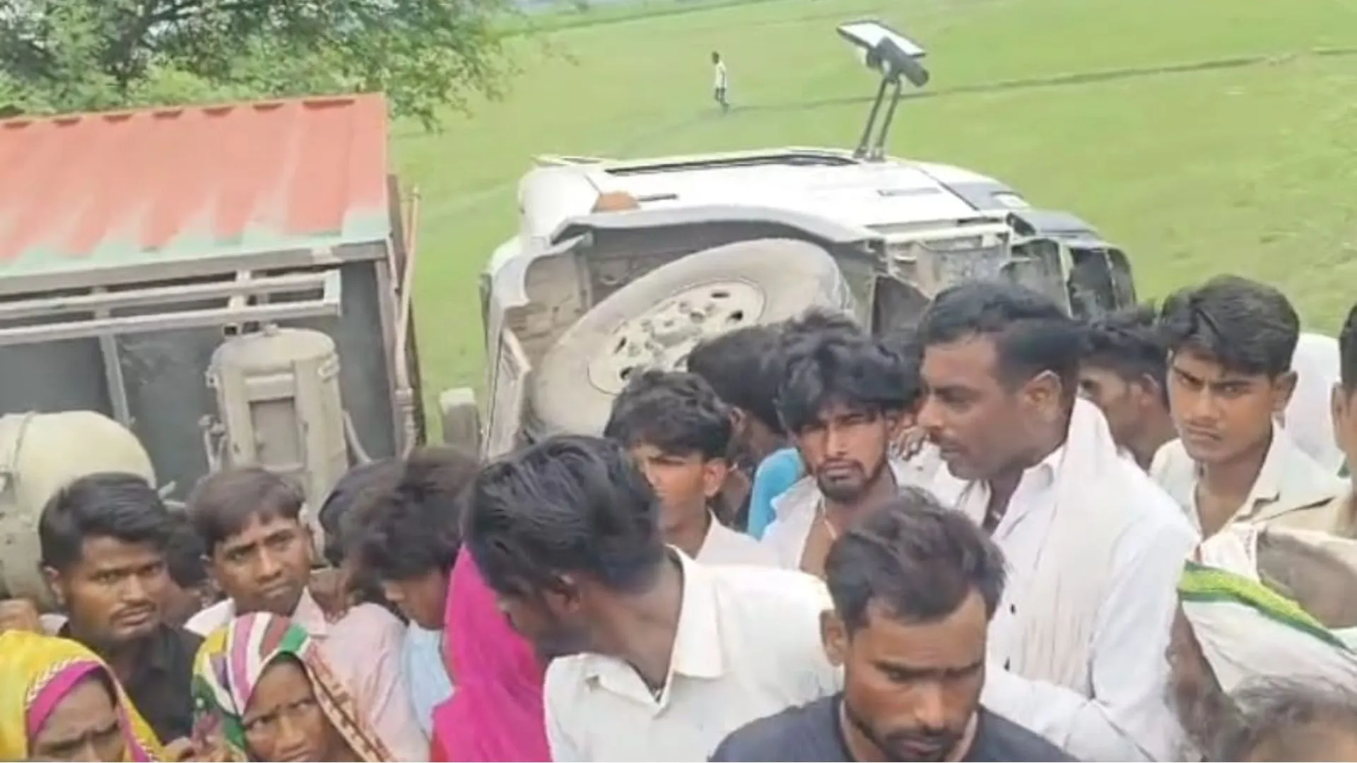 Badaun News : बदायूं में सड़क किनारे बैठे तीन लोगों पर पलटा कंटेनर, बुजुर्ग की मौत-दो बच्चियों की हालत गंभीर