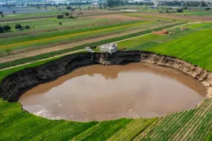 खेत में बना गड्ढा देखते ही देखते फुटबॉल मैदान से भी ज्यादा हो गया बड़ा