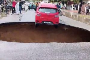 लखनऊ में बारिश के चलते विकास नगर में धंसी सड़क, लटकी कार, देखें वीडियो